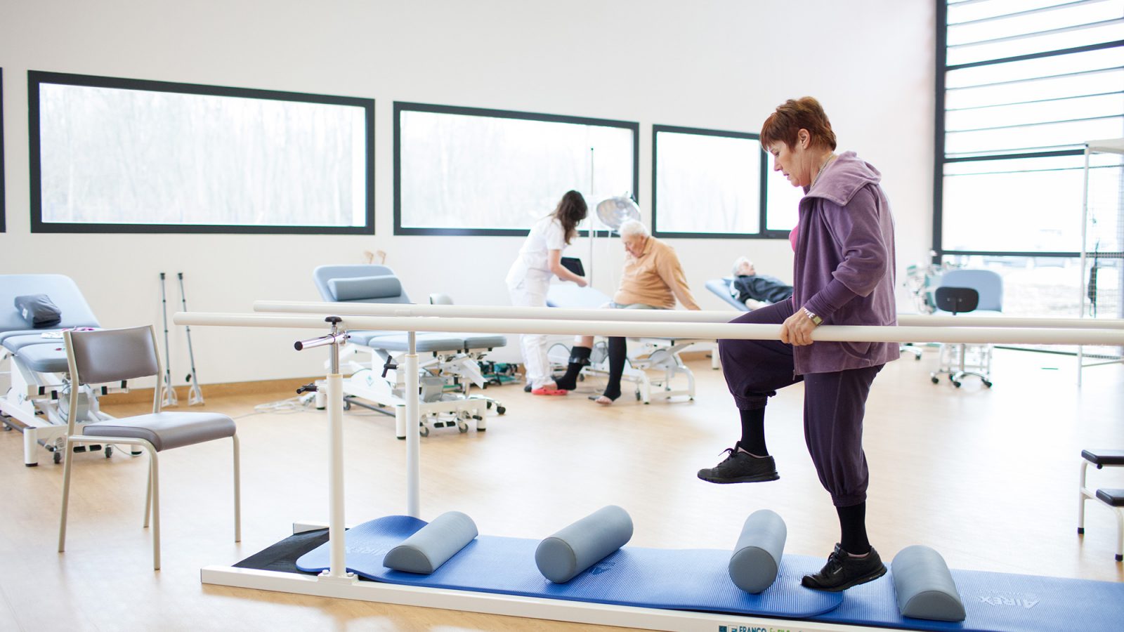 Une patiente pratique un éxercice de marche en évitant des obstacles